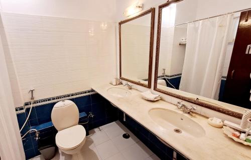 uma casa de banho com um WC, um lavatório e um espelho. em Mahendra Prakash em Udaipur