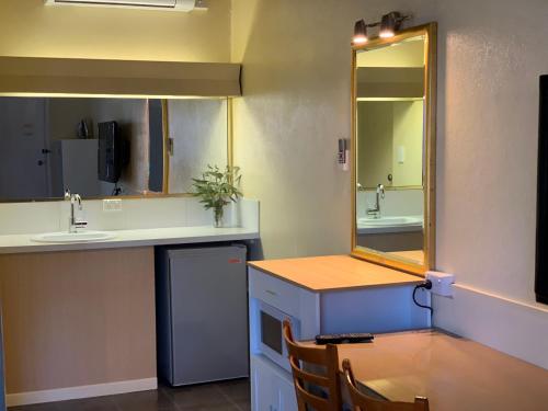 La salle de bains est pourvue d'un lavabo et d'un comptoir avec un miroir. dans l'établissement Temora Motel, à Temora