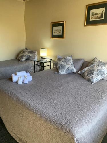a bedroom with a large bed with towels on it at Temora Motel in Temora