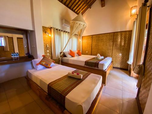 a bedroom with two beds and a window at Sayang Mama Inn in Gili Air