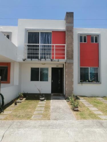 une maison avec un rouge et un blanc dans l'établissement hermosa casa en coto privado especialmente para ti, 