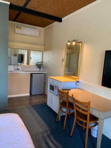 a kitchen with a table and two chairs in a room at Temora Motel in Temora