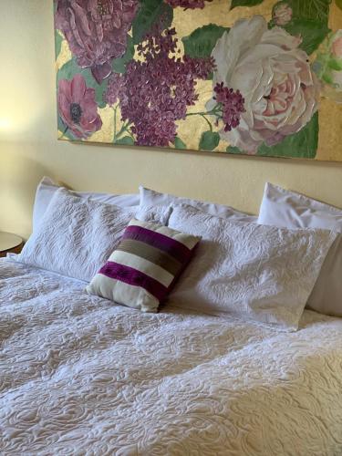 a bed with two pillows and a painting on the wall at Temora Motel in Temora