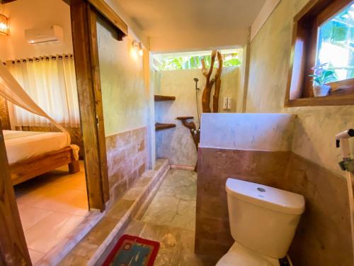 a bathroom with a toilet and a shower in it at Sayang Mama Inn in Gili Air