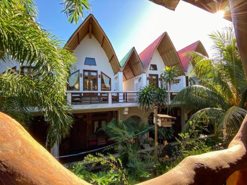 a house with a lot of trees in front of it at Sayang Mama Inn in Gili Air