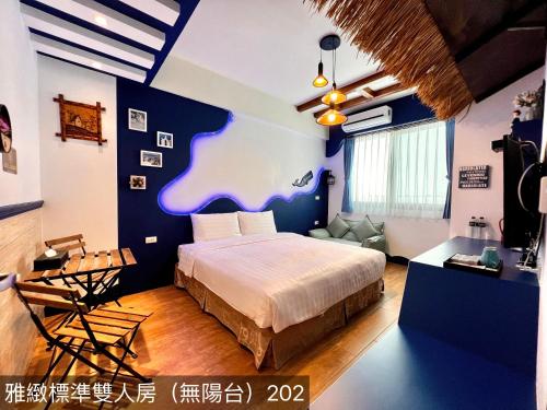 a bedroom with a bed and a living room at Summer Bay Inn in Hengchun