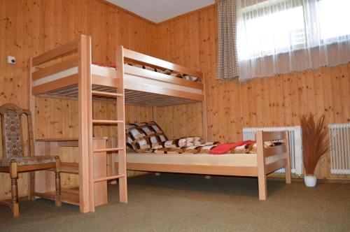 1 Schlafzimmer mit 2 Etagenbetten und einem Stuhl in der Unterkunft Apartman Kammleitn in Hermagor