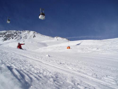 a person skiing down a snow covered slope with a ski lift at Villa Relax am See in Bodensdorf