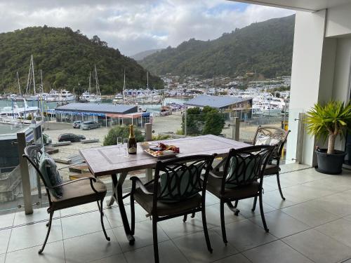 a table and chairs on a balcony with a view of a harbor at Oxley's Waterfront Apartment in Picton