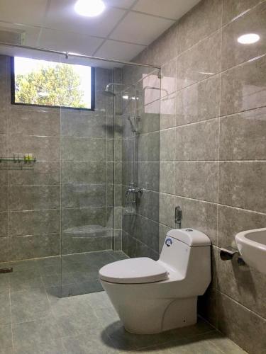 a bathroom with a toilet and a shower and a sink at The Cau Garden House in Ấp Long Hồ Hạ