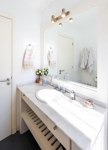 a white bathroom with a sink and a mirror at Hermosa habitación en apartamento en Carrasco - Comparte Apartamento conmigo in Montevideo