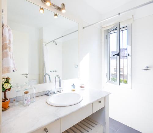 a white bathroom with a sink and a mirror at Hermosa habitación en apartamento en Carrasco - Comparte Apartamento conmigo in Montevideo