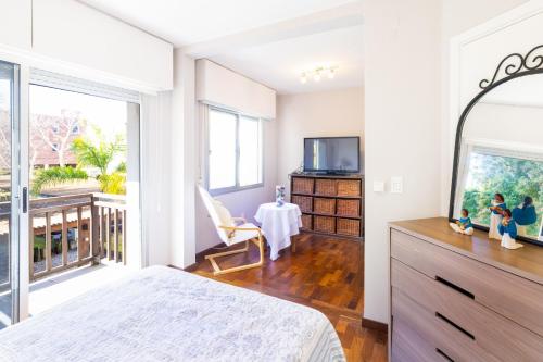 a bedroom with a bed and a balcony with a table at Hermosa habitación en apartamento en Carrasco - Comparte Apartamento conmigo in Montevideo