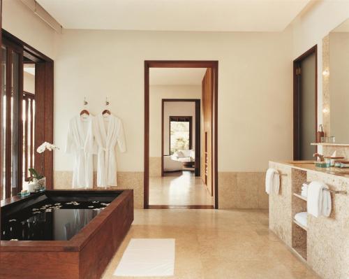COMO Shambhala Estate في بيانغان: حمام مع حوض استحمام ومرآة