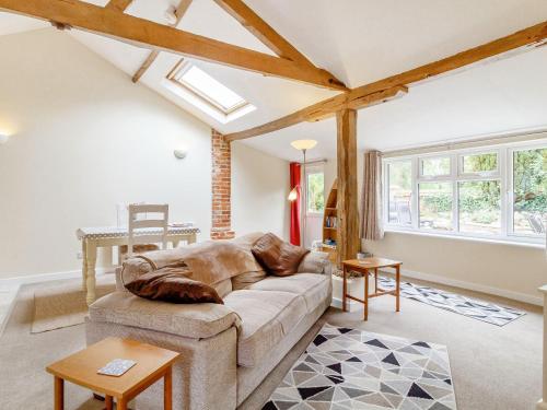 a living room with a couch and some windows at The Hen House in Diss