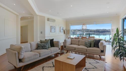 a living room with two couches and a table at Market Street Penthouse in Merimbula