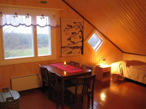 Un dormitorio con una mesa y una cama con una vela. en Farmhouse Tervamäki, en Tervajärvi