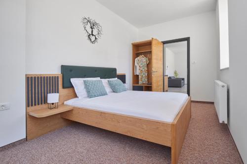 - une chambre avec un lit et une tête de lit en bois dans l'établissement Ob Krki Apartments, à Kostanjevica na Krki