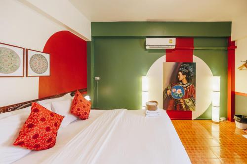 Un dormitorio con una cama blanca con paredes rojas y verdes en Sleeper House, en Trang