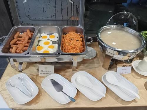 a buffet with eggs and other food on a table at Siri Hotel Lumphun in Ban Pa Daet
