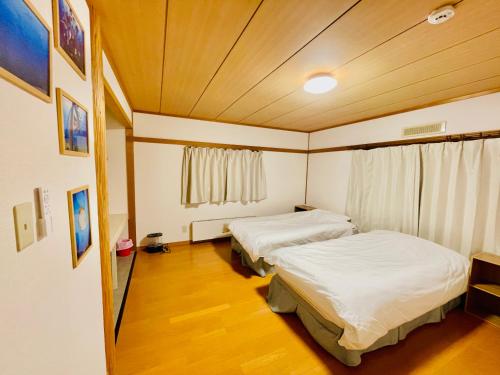 1 Schlafzimmer mit 2 Betten und einem Fenster in der Unterkunft Yellow House Niseko in Kutchan