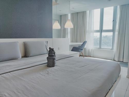 ein weißes Schlafzimmer mit einem großen Bett und einem Stuhl in der Unterkunft Verve Suites KL South in Kuala Lumpur