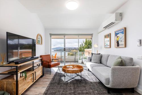 a living room with a couch and a tv at Kooringa 4 - 2BR Apartment l Lake Views l Central Location l BBQ l WiFi l Air-Con in Jindabyne