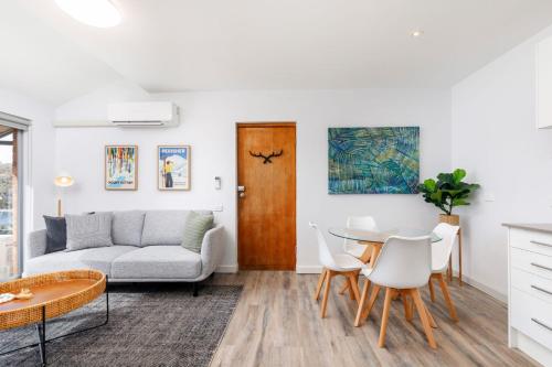 a living room with a couch and a table at Kooringa 4 - 2BR Apartment l Lake Views l Central Location l BBQ l WiFi l Air-Con in Jindabyne