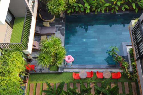 an overhead view of a pool with red chairs and plants at K-House vs Apartment in Da Nang