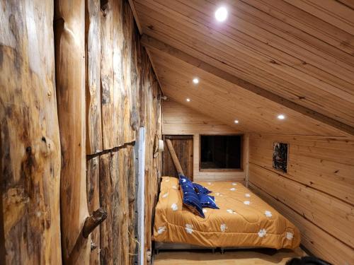 a room with a bed in a log cabin at La chala Guatavita in Guatavita