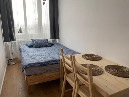 カトヴィツェにあるon the cornerのベッドルーム1室(ベッド1台、木製テーブル、椅子付)