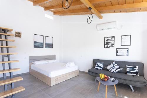 een slaapkamer met een bed, een bank en een tafel bij Spitakia-Cozy & Comfy Apartments 10minutes from the airport in Artemida