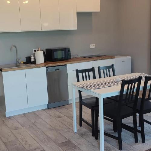 a kitchen with a table and chairs and a counter at Apartamenty Wilga spokojne miejsce z całorocznym jacuzzi i letnim basenem in Wilga