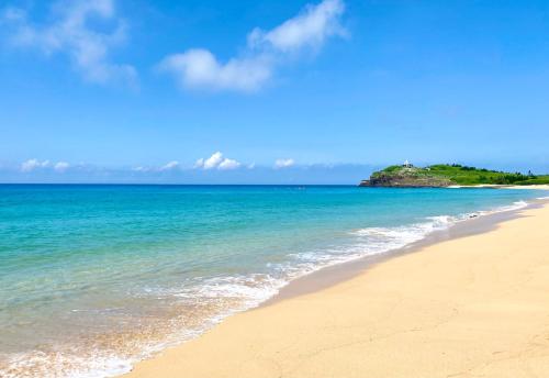 una playa vacía con una isla a lo lejos en 澎湖北吉光背包客民宿 Bayhouse Hostel Penghu, en Magong