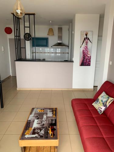 uma sala de estar com um sofá vermelho e uma mesa em TICOMBAVA à la Possession em La Possession