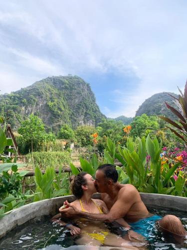 a man and woman kissing in a pool of water at Trang An Lamia Bungalow in Ninh Binh
