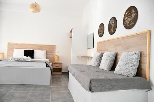 ein Schlafzimmer mit 2 Betten und Uhren an der Wand in der Unterkunft Heliofos Apartments in Stomio