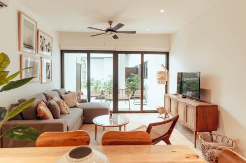 a living room with a couch and a tv at Stylish Luxury Condo in the heart of Playa in Playa del Carmen