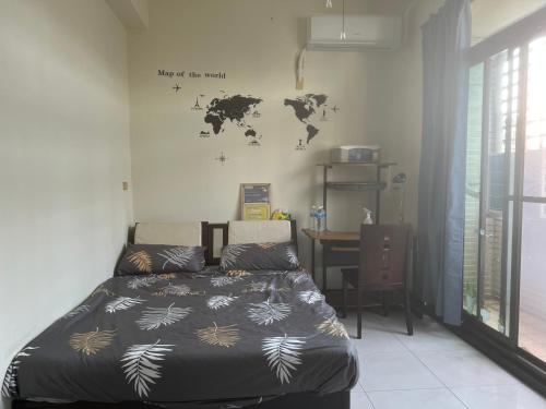 a bedroom with a bed and a world map on the wall at 近交流道仁德四樓雅房 in Rende