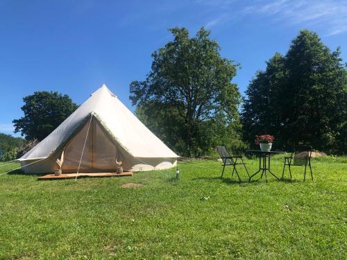 a tent with chairs and a table in a field at Lahemaa Glamping in Viinistu