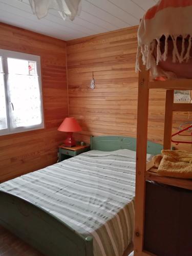 a bedroom with a bunk bed and a window at La petite maison dans la prairie 
