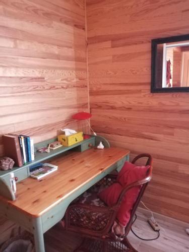 a desk in a room with a wooden wall at La petite maison dans la prairie 
