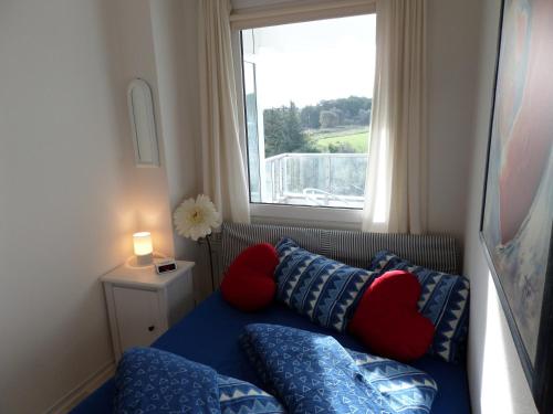 グリュックスブルクにあるMeeresbrise Schausendeのソファ、枕、窓が備わる客室です。