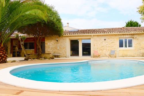 una gran piscina frente a una casa en Charmante Chartreuse Bordelaise - Ancien Chai, en Tabernottes