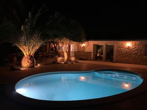 una gran piscina azul en un patio por la noche en Charmante Chartreuse Bordelaise - Ancien Chai, en Tabernottes