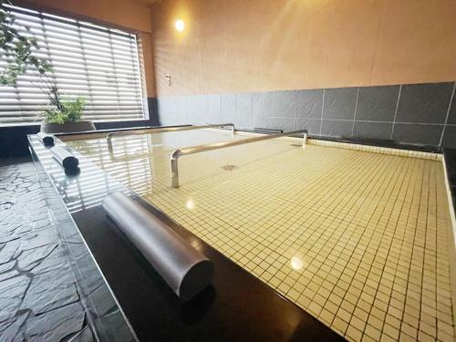 a swimming pool with a tub in a room at Hotel Abest Grande Okayama in Okayama