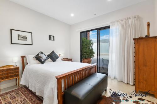 a bedroom with a bed and a large window at Hideaway Nook by Wine Coast Holiday Rentals in Willunga