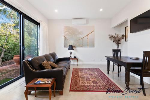 a living room with a couch and a table at Hideaway Nook by Wine Coast Holiday Rentals in Willunga