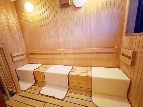 a small sauna with two white seats in it at Hotel Abest Grande Okayama in Okayama