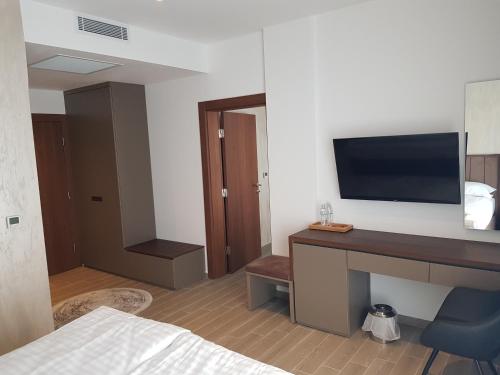 a hotel room with a desk with a tv on the wall at MY HOTEL in Prizren